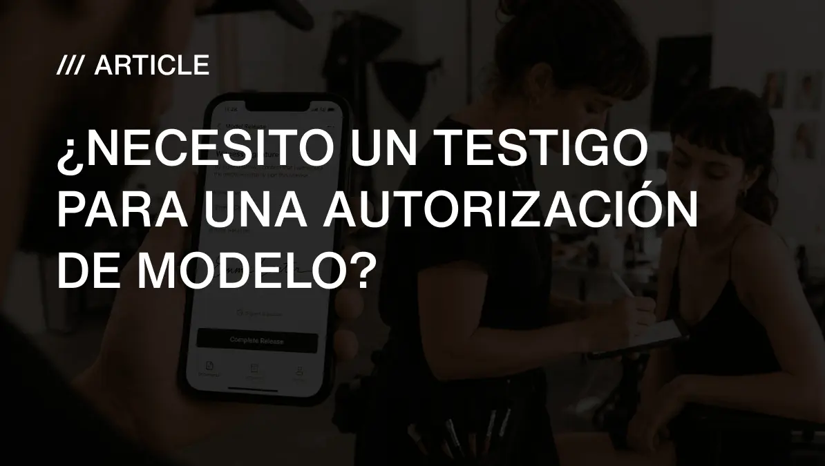 Un fotógrafo mostrando la app Model Release App con el campo de testigo abierto en su móvil, mientras un maquillador firma como testigo en el set